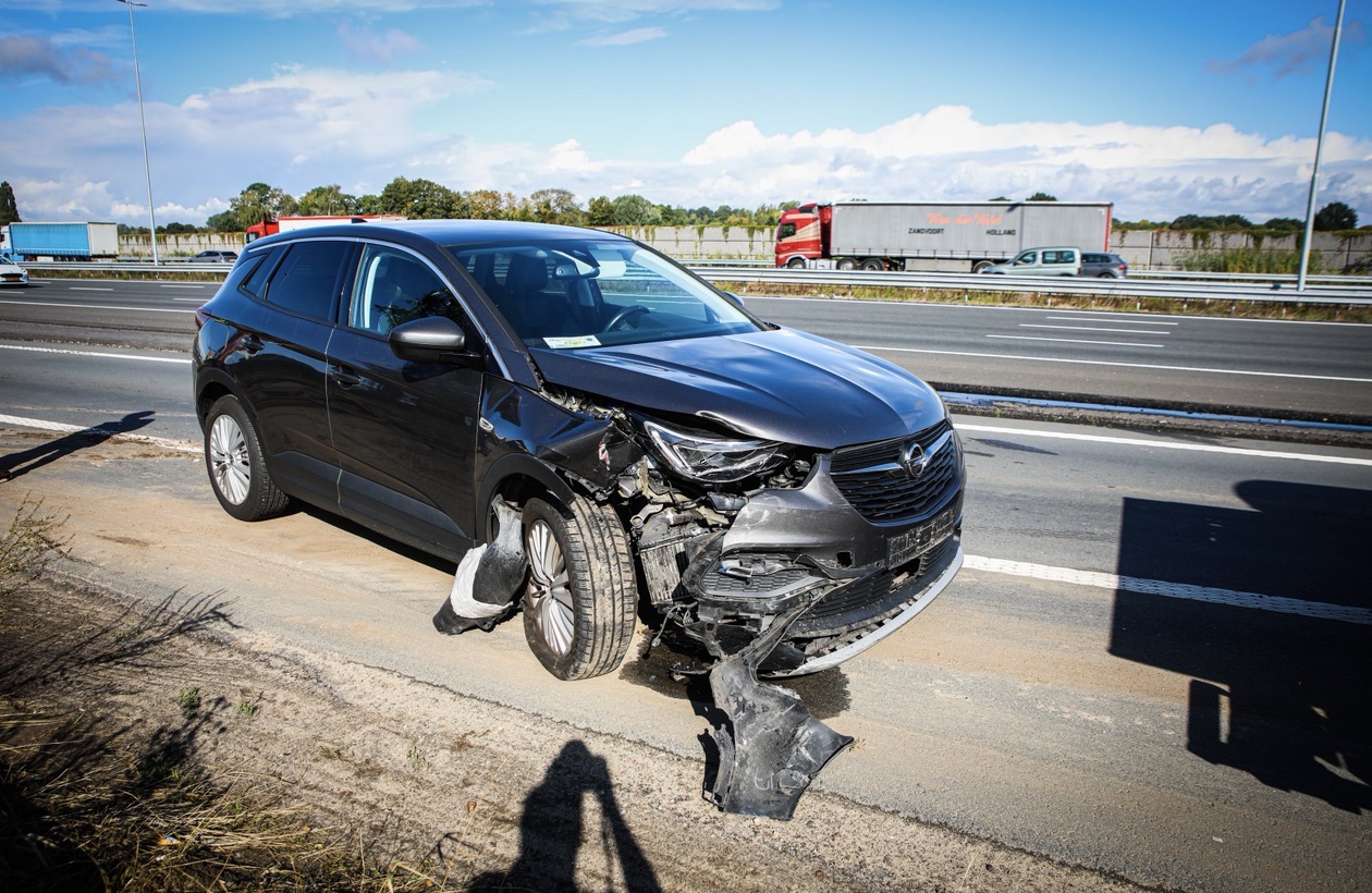 Twee auto’s botsen op snelweg; voertuigen belanden op vluchtstrook - foto
