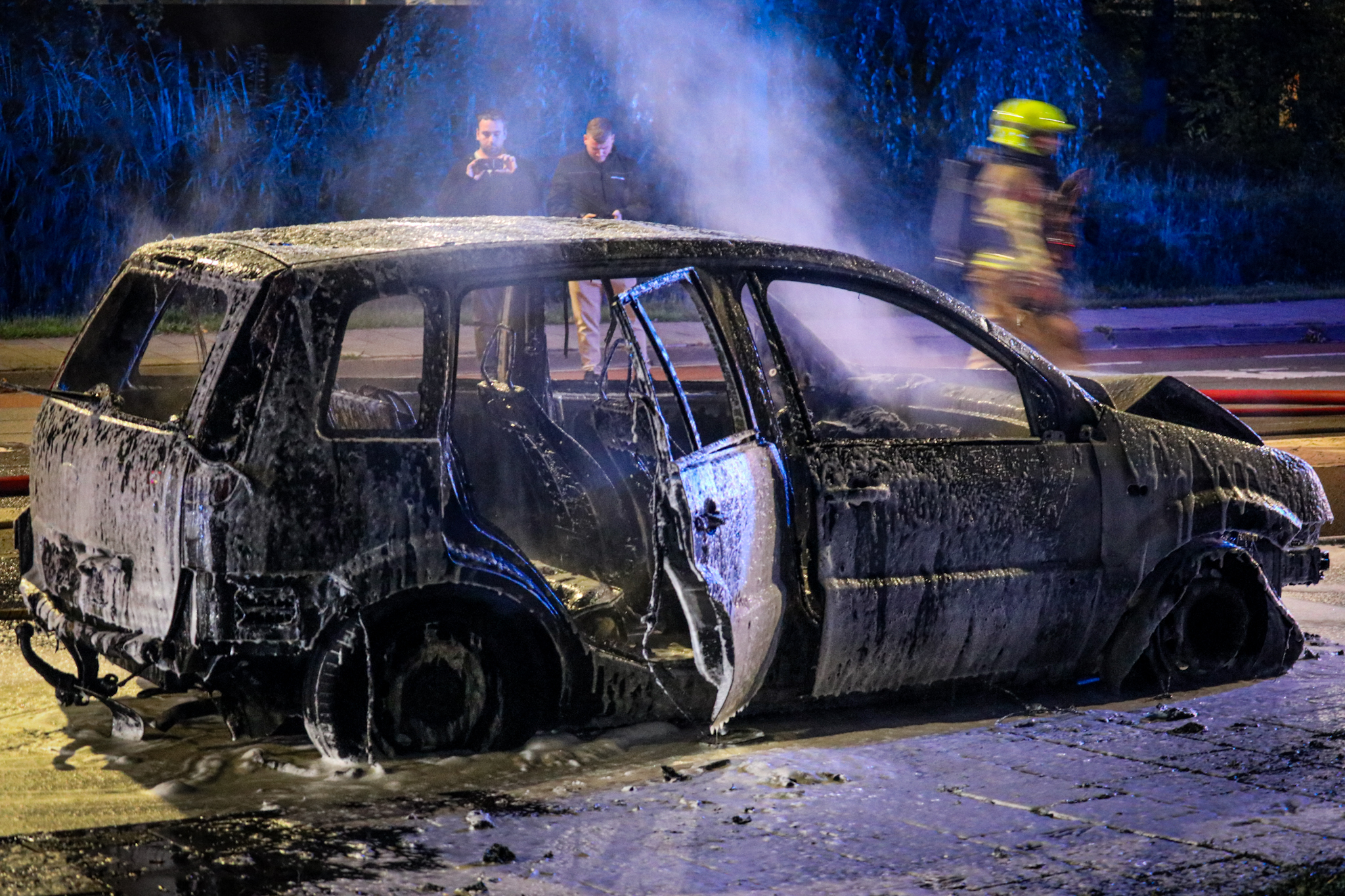 Rijdende auto vliegt in brand, brandweer zet water en schuim in - foto