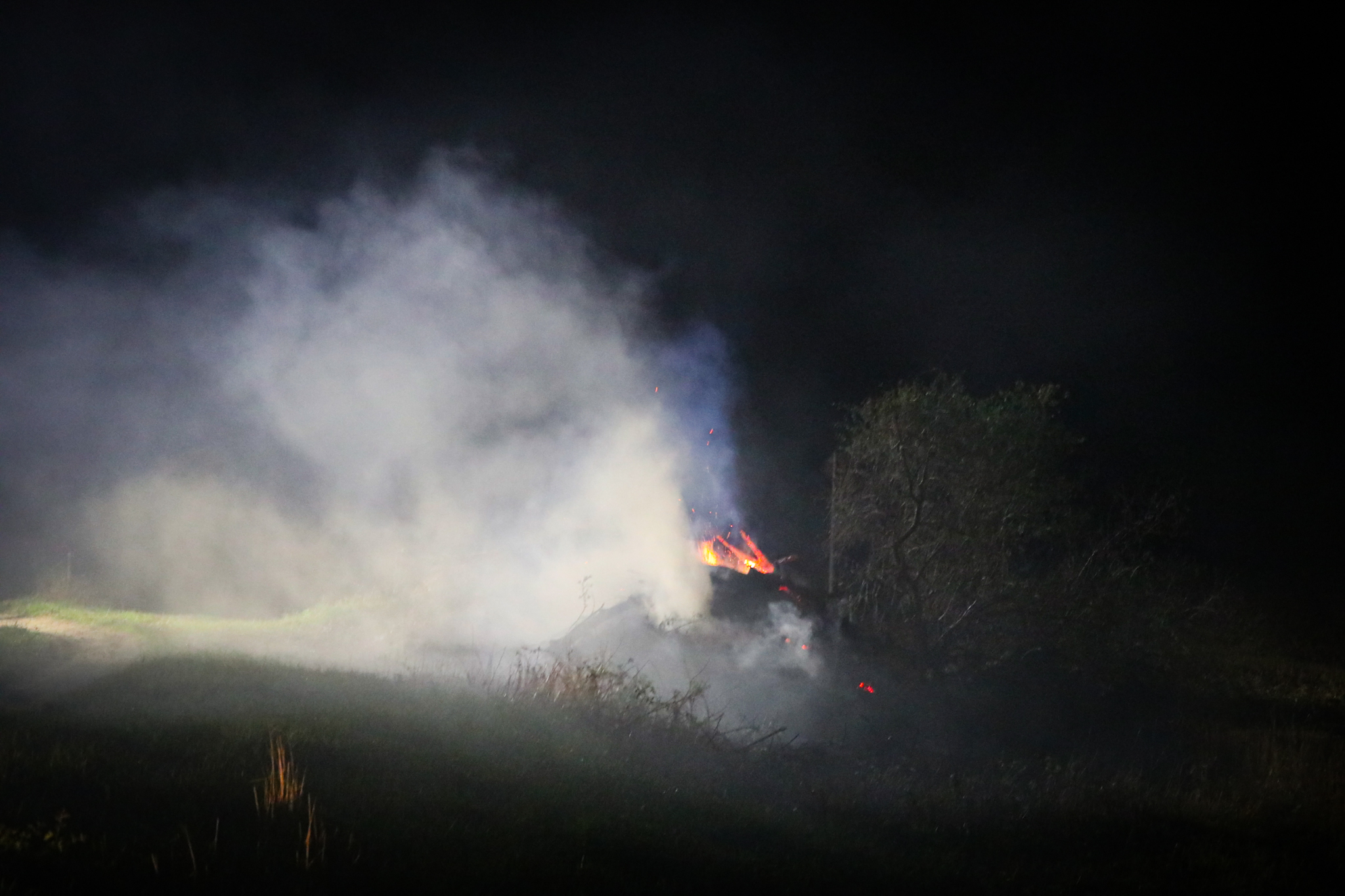 Brandweer uren bezig met brandende stapel agrarisch afval - foto