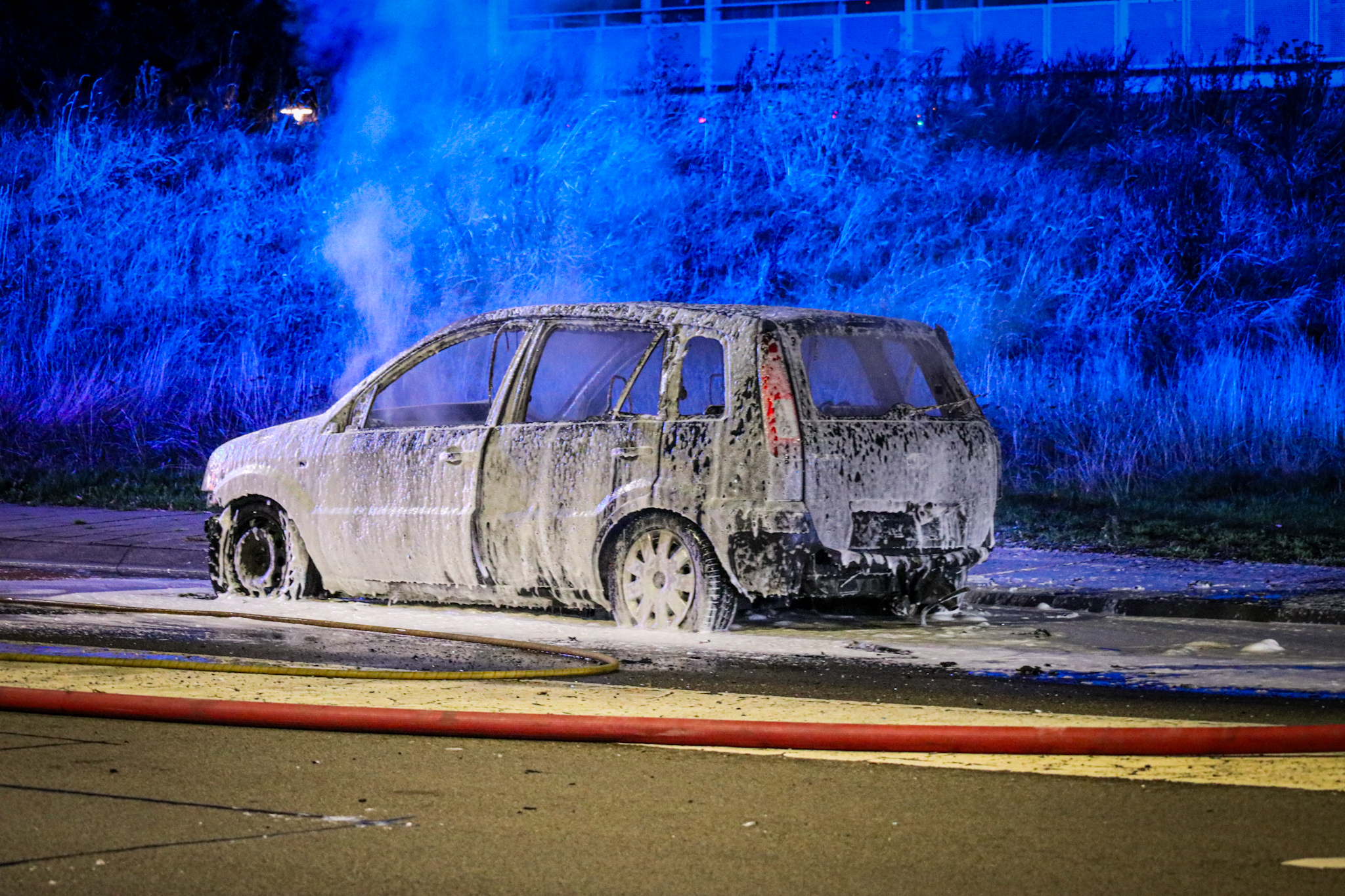 Rijdende auto vliegt in brand, brandweer zet water en schuim in