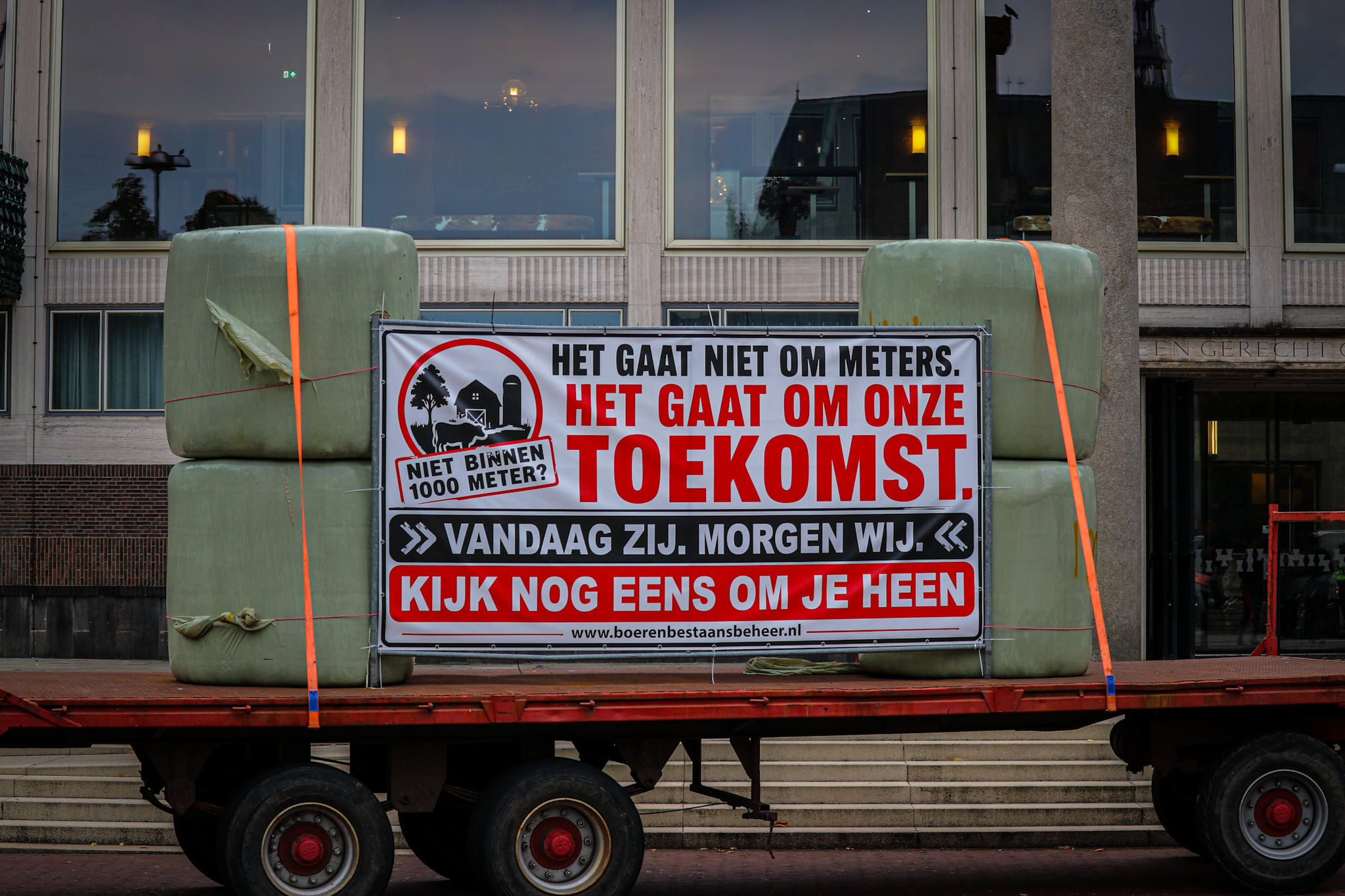 Tractoren en hooibalen met protestteksten voor provinciehuis